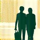 Due persone che camminano e conversano all'aperto, in un 'walking meeting'.