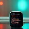 Dispositivi indossabili tecnologici come smartwatch e sensori di attività, su una superficie moderna e pulita.